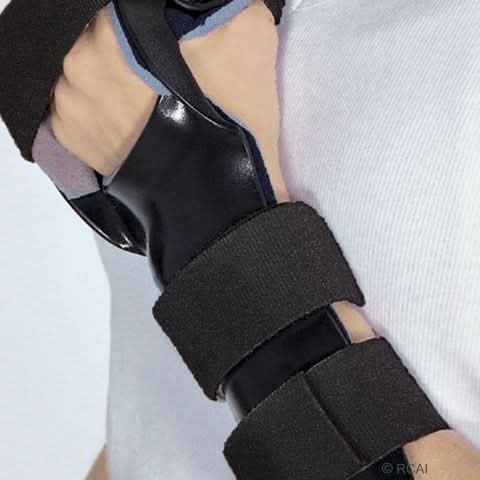 Black RCAI dorsal resting hand orthosis with finger separators, secured with soft black adjustable straps, worn on left.