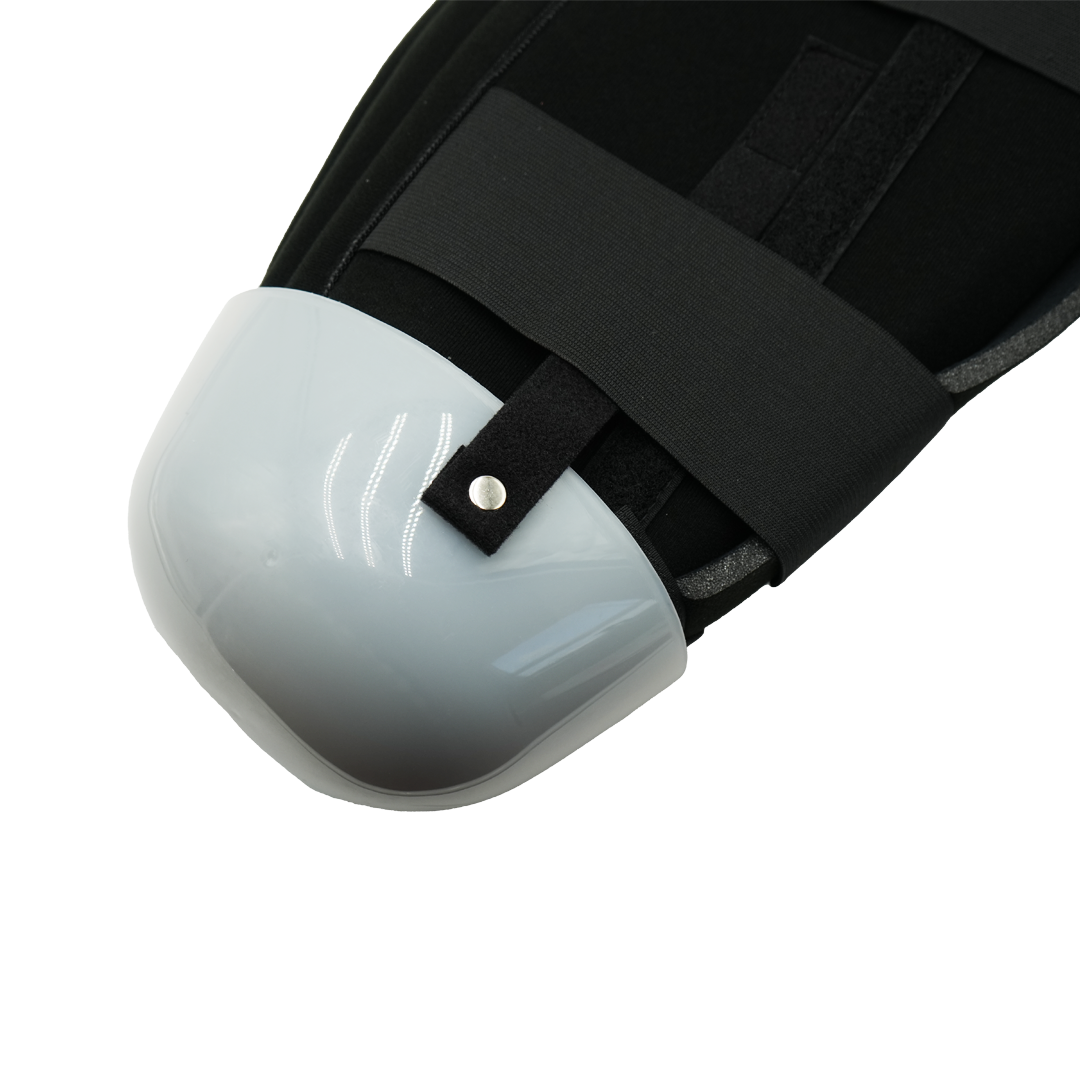 Below knee amputee rigid dressing protector with glossy white single panel and black adjustable straps, made in the USA by.