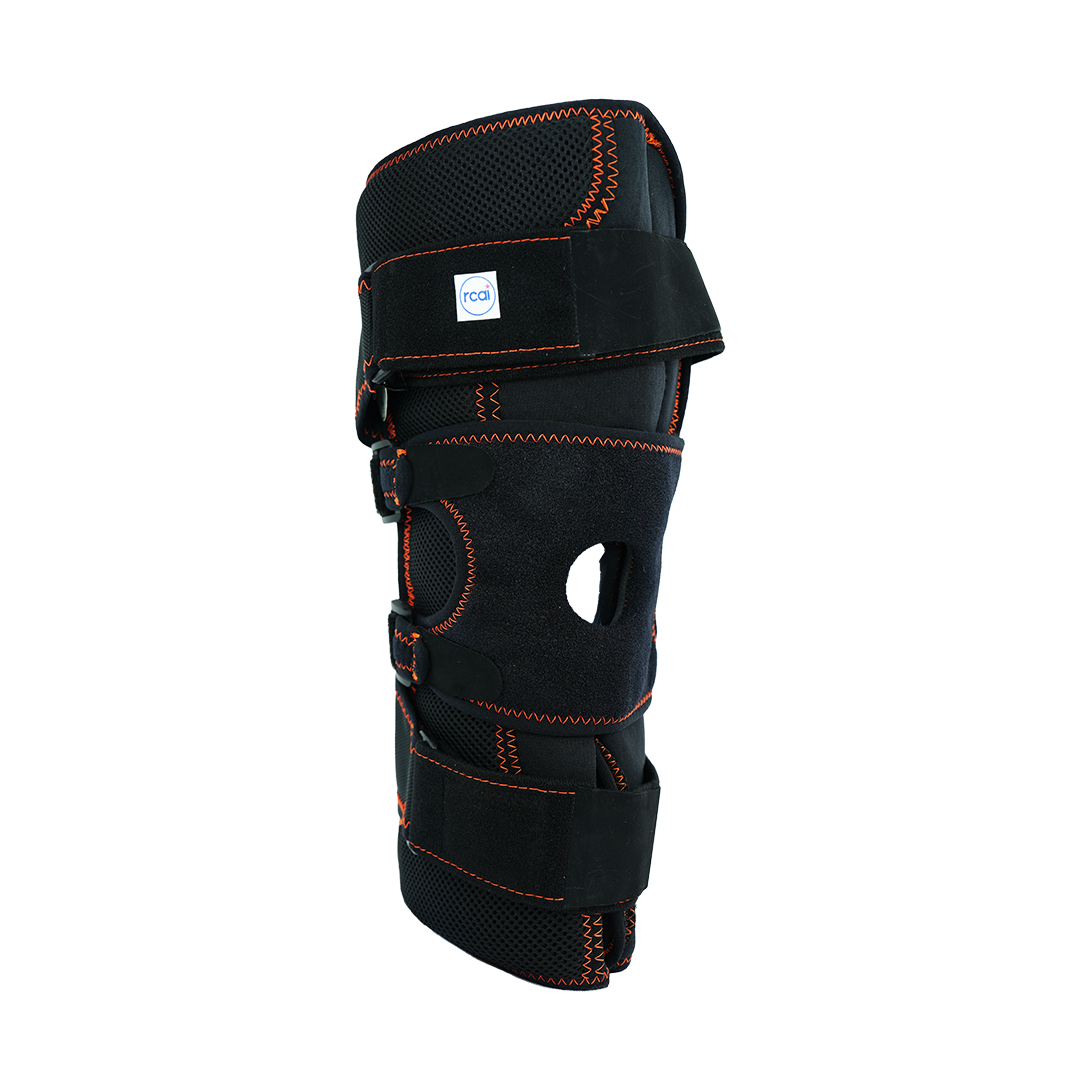 Black neoprene knee brace with orange stitching, adjustable Velcro straps, open patella design, made in the USA, RCAI logo.