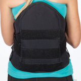 Black lumbar sacral support with side panels worn over a turquoise shirt, featuring wide adjustable straps and sturdy back.