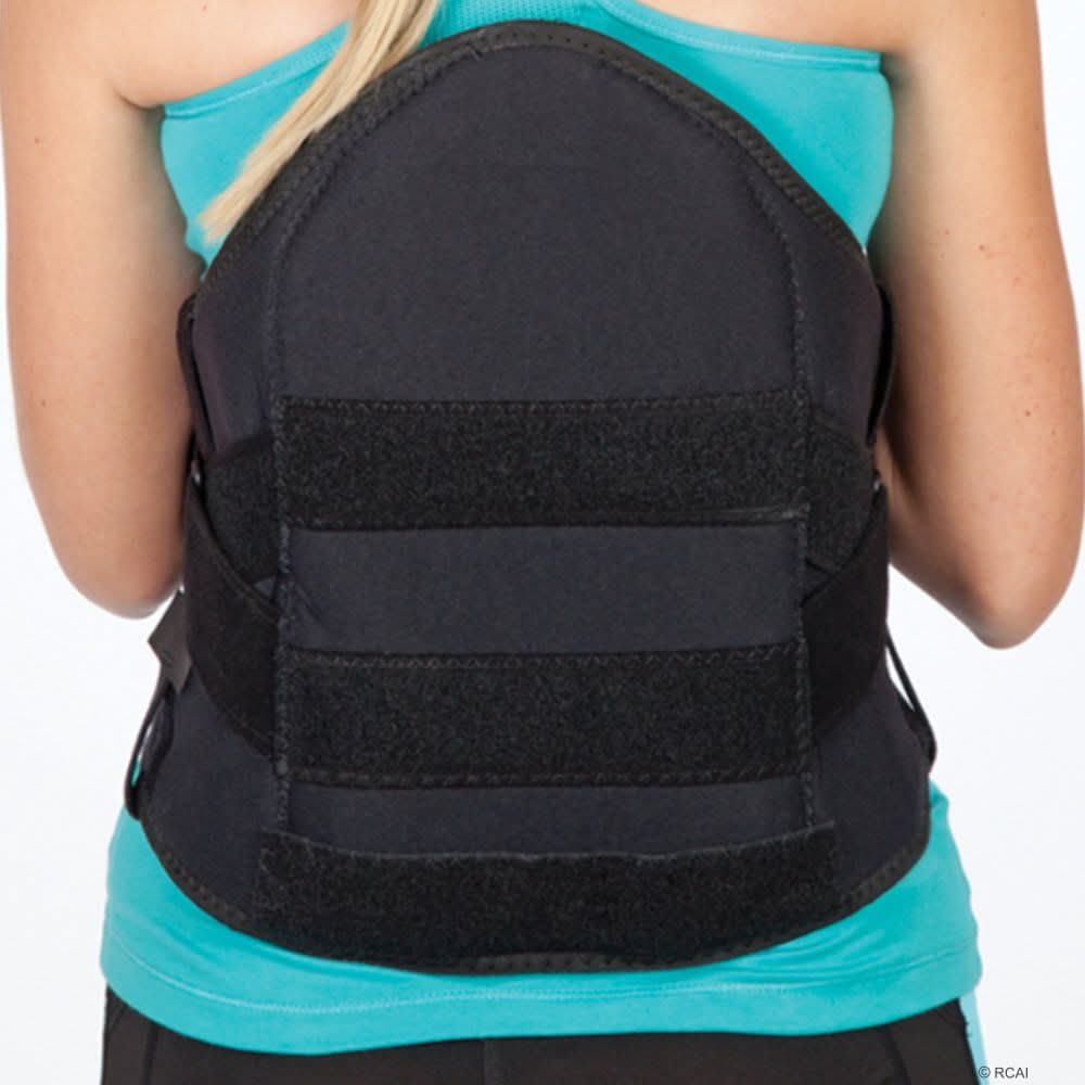 Black lumbar sacral support with side panels worn over a turquoise shirt, featuring wide adjustable straps and sturdy back.