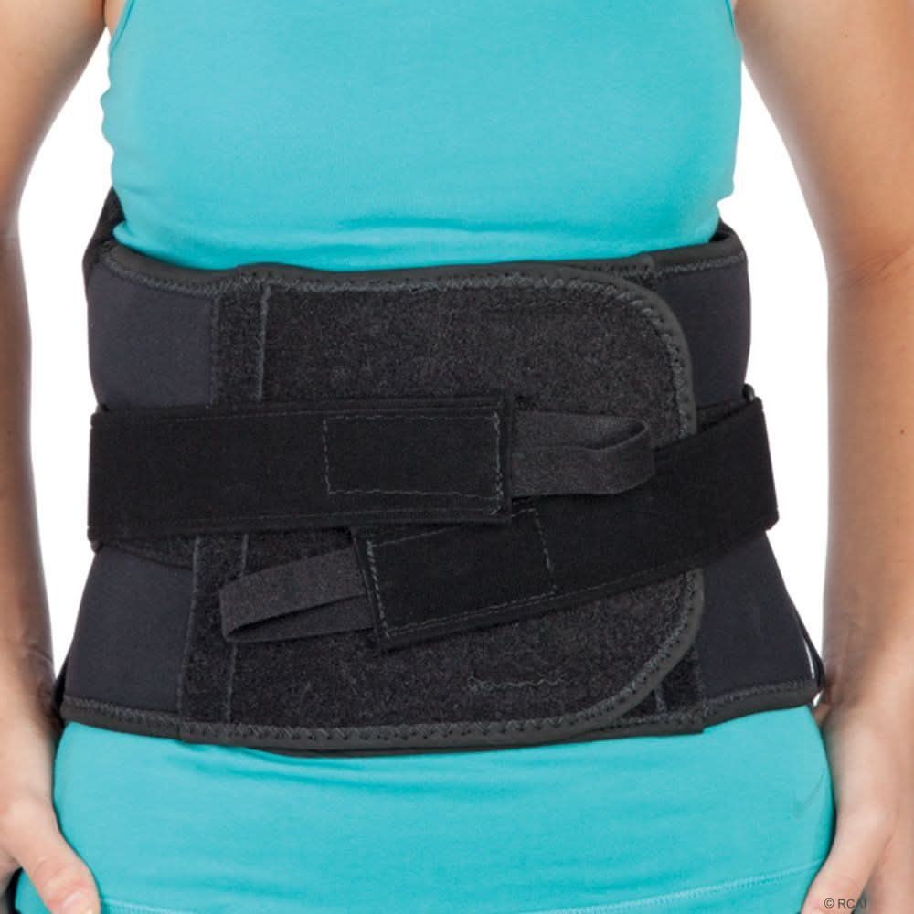 Black lumbar sacral support with side panels secured around waist over teal shirt, reinforced straps for adjustable fit,.