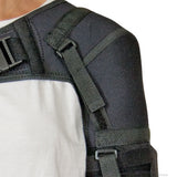 Black neoprene shoulder stabilizer with adjustable straps and buckle, worn over white shirt, made in the USA, best.