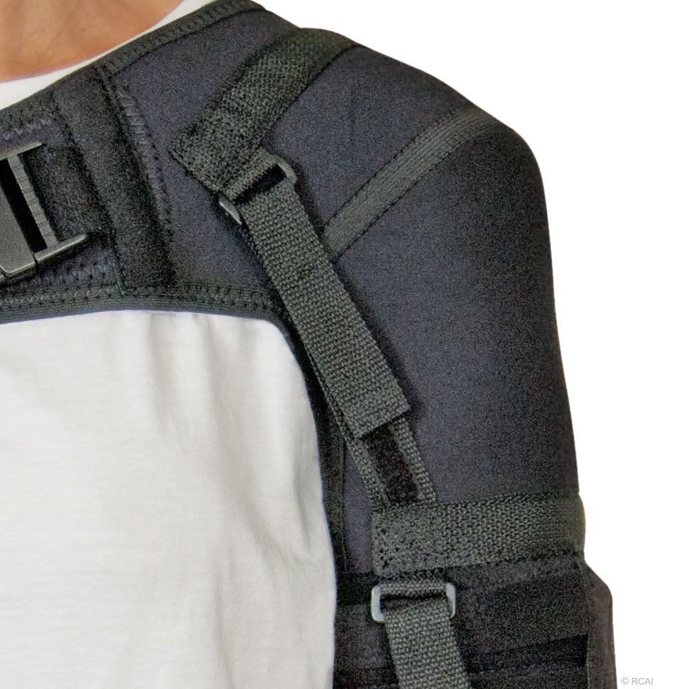 Black neoprene shoulder stabilizer with adjustable straps and buckle, worn over white shirt, made in the USA, best.