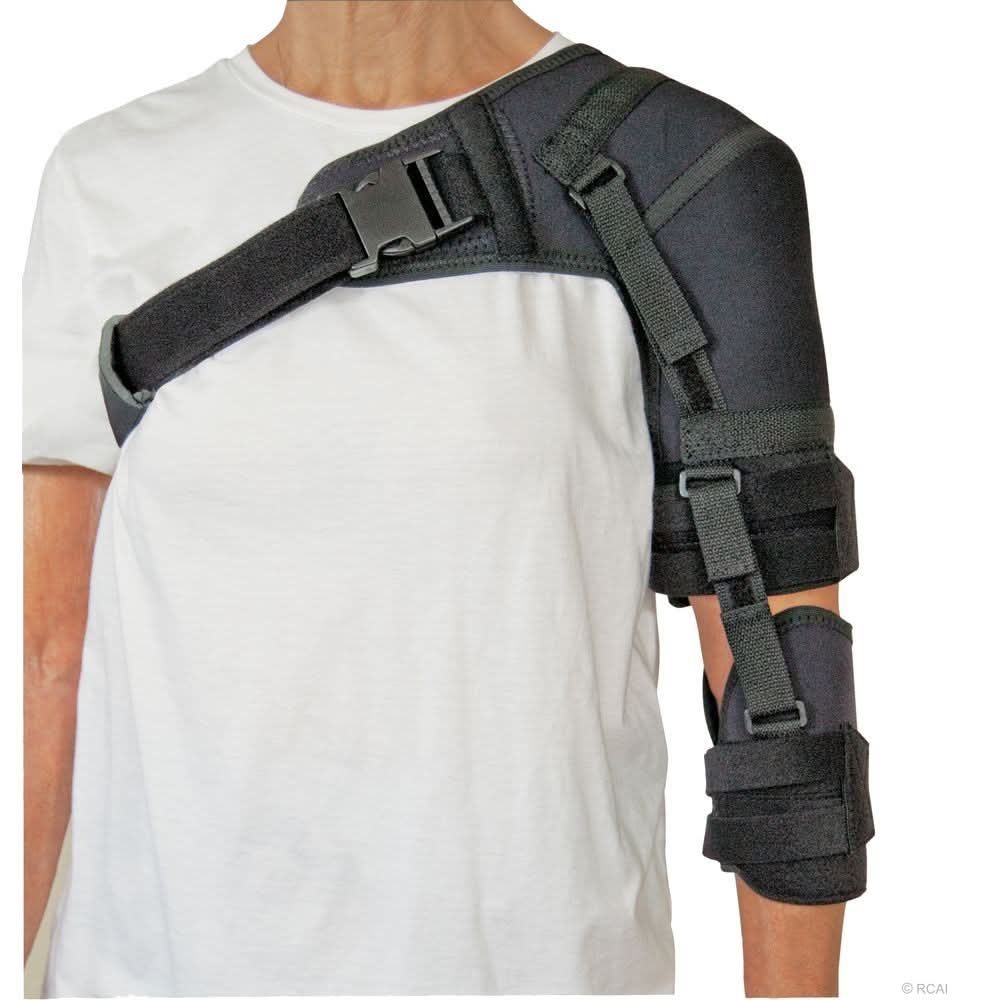Black neoprene shoulder stabilizer with adjustable straps and buckles on right arm, worn over white shirt, made in the USA,.